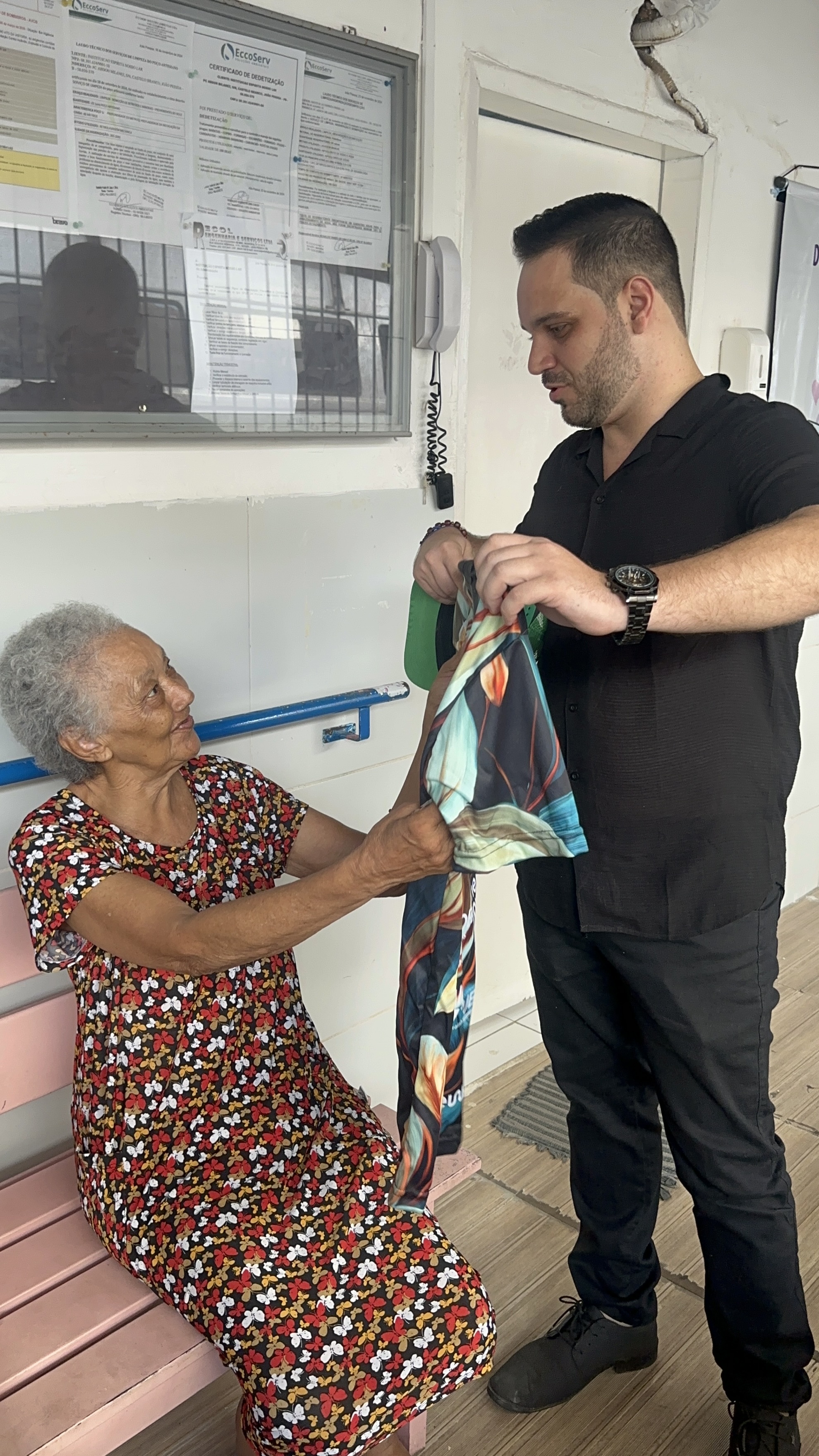 Malory entregando presente a idosa no asilo